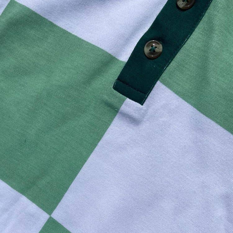 Close-up of a green and white checkered shirt with a button.
