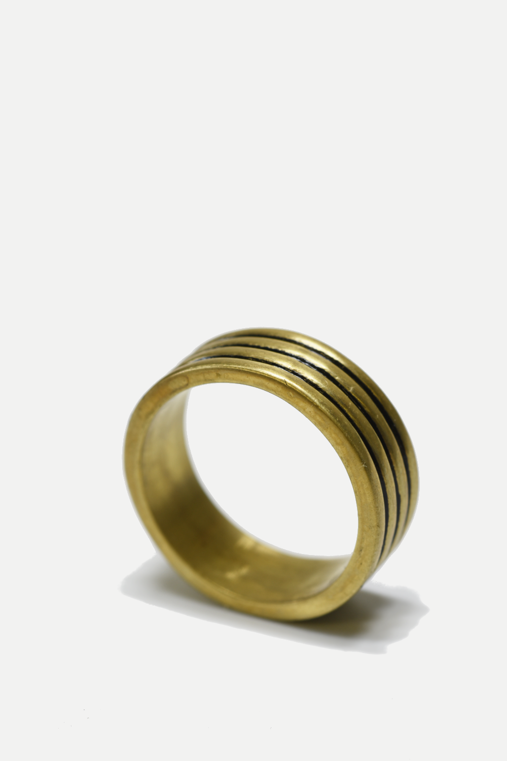 Gold ring with concentric grooves on a white background