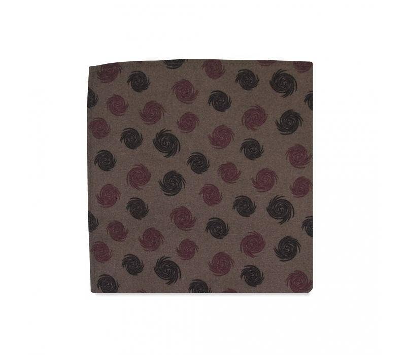 Fabric swatch with a pattern of red and black swirls on a brown background