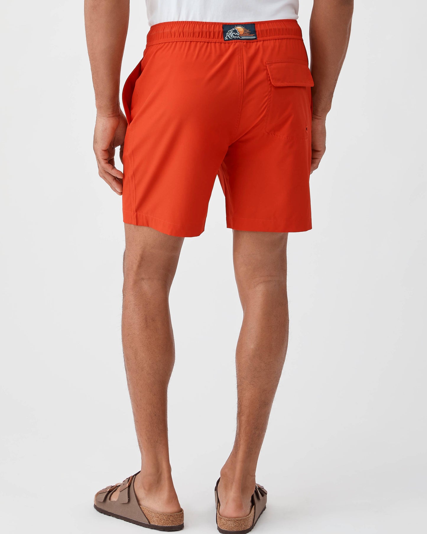 Person wearing bright orange shorts on a white background