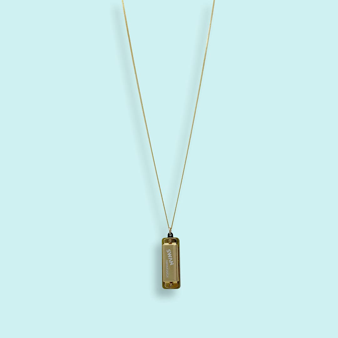 Gold necklace with a pendant on a light blue background