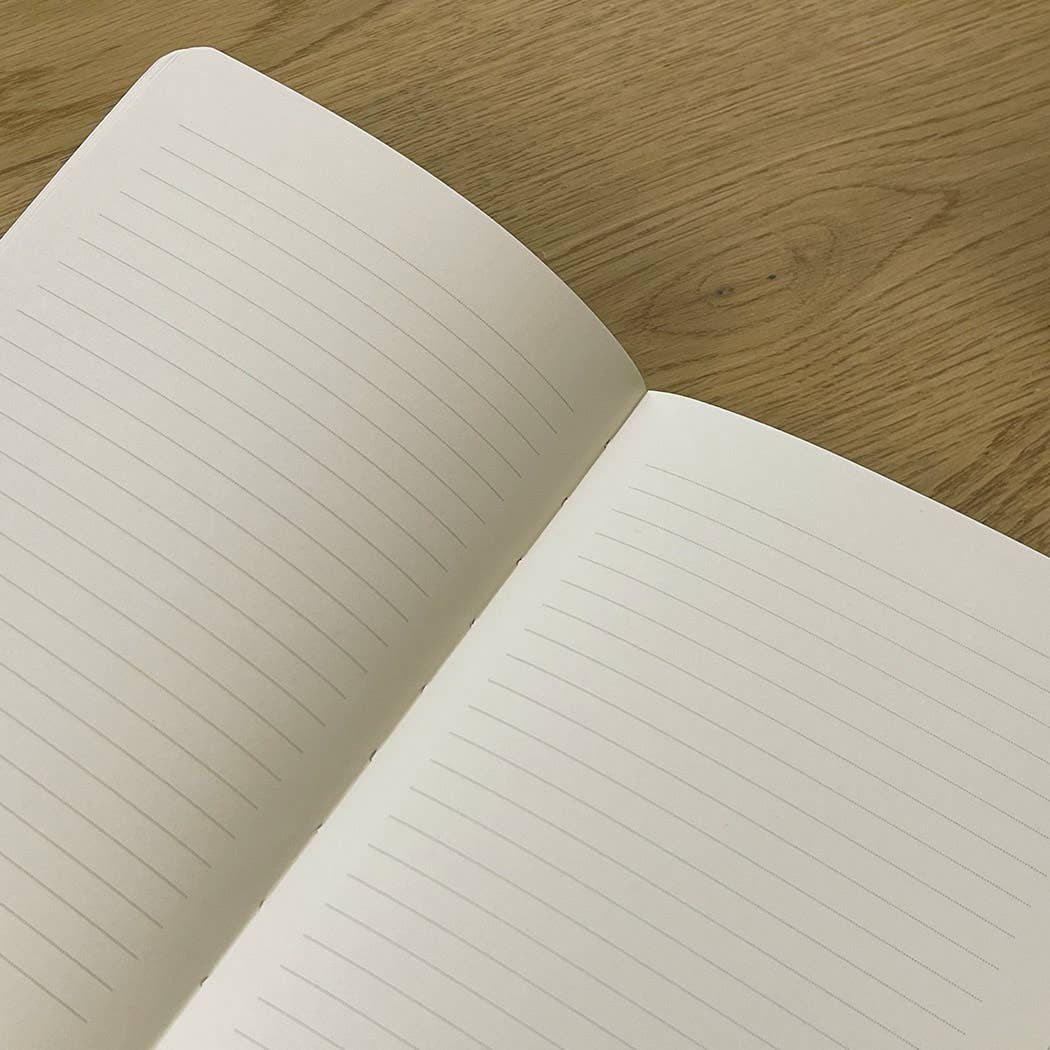 Open notebook with lined pages on a wooden surface
