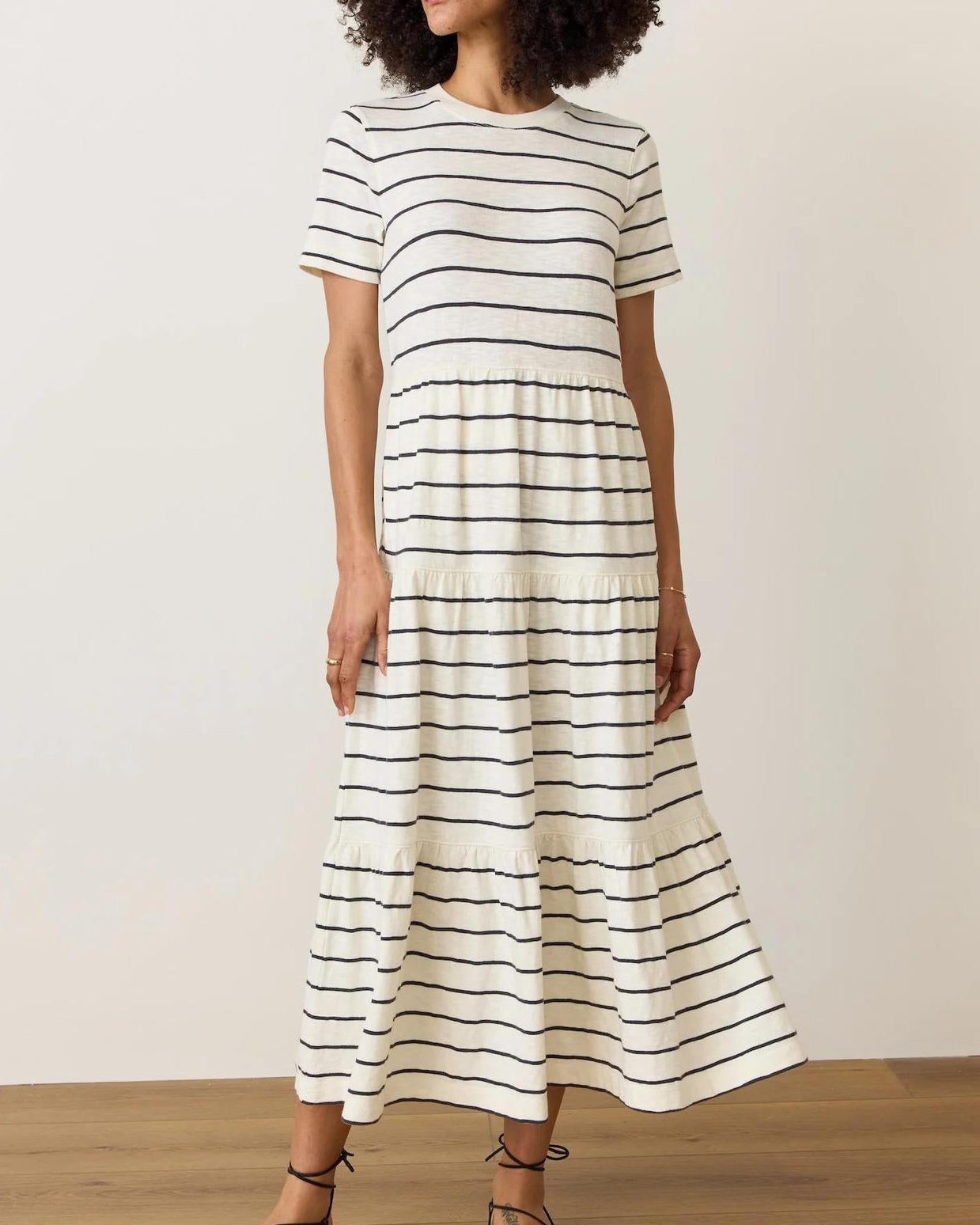 Woman wearing a black and white striped dress against a plain background