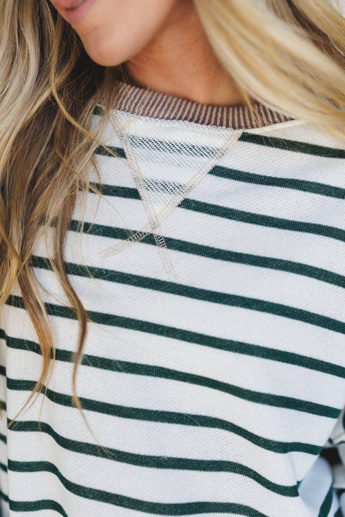 Close-up of a person wearing a striped shirt with green and white horizontal stripes.