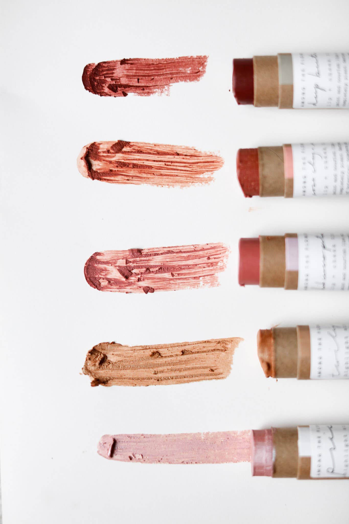 Lip balm sticks with swatches of color on a white background
