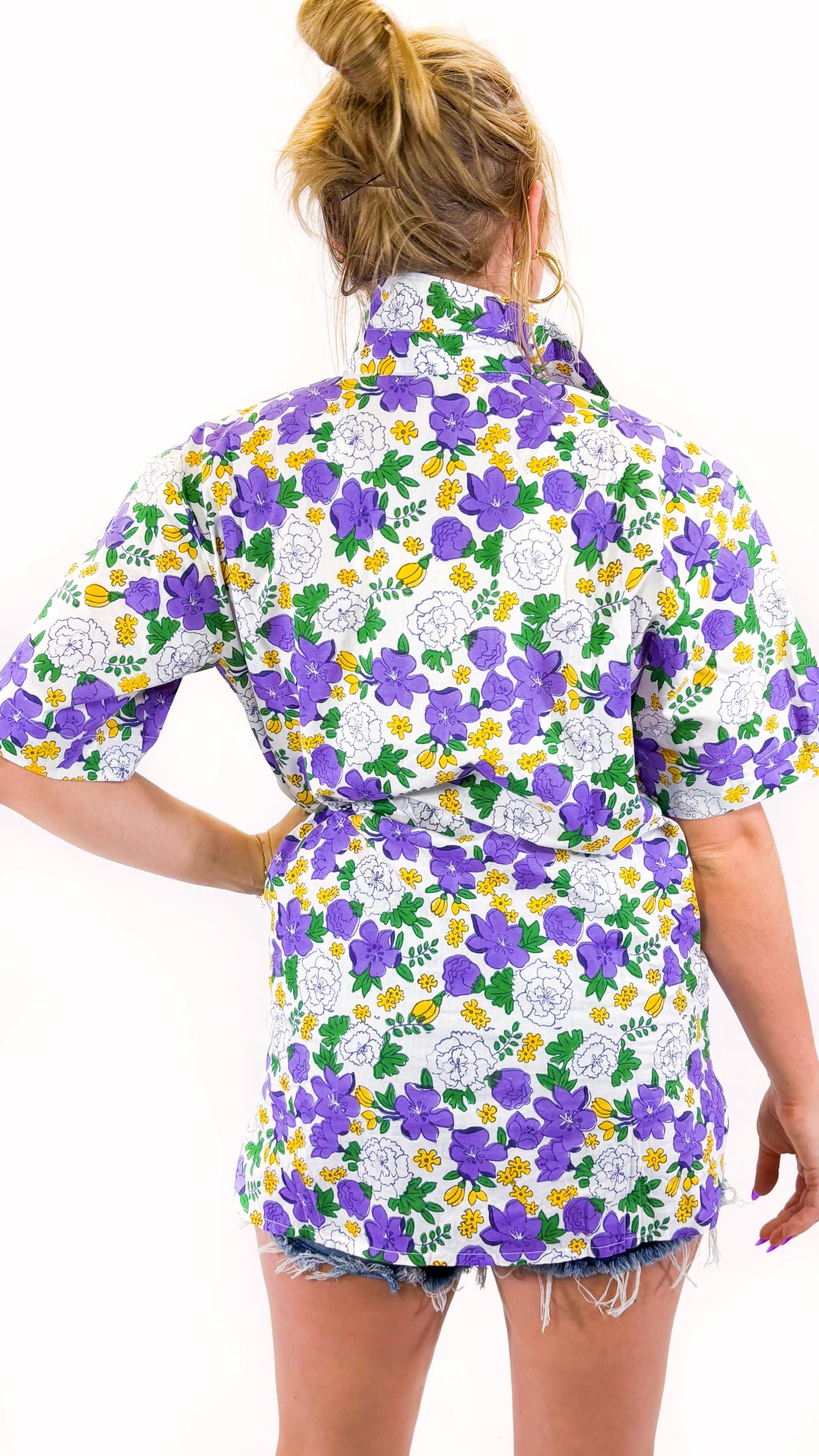 Woman wearing a colorful floral shirt on a white background