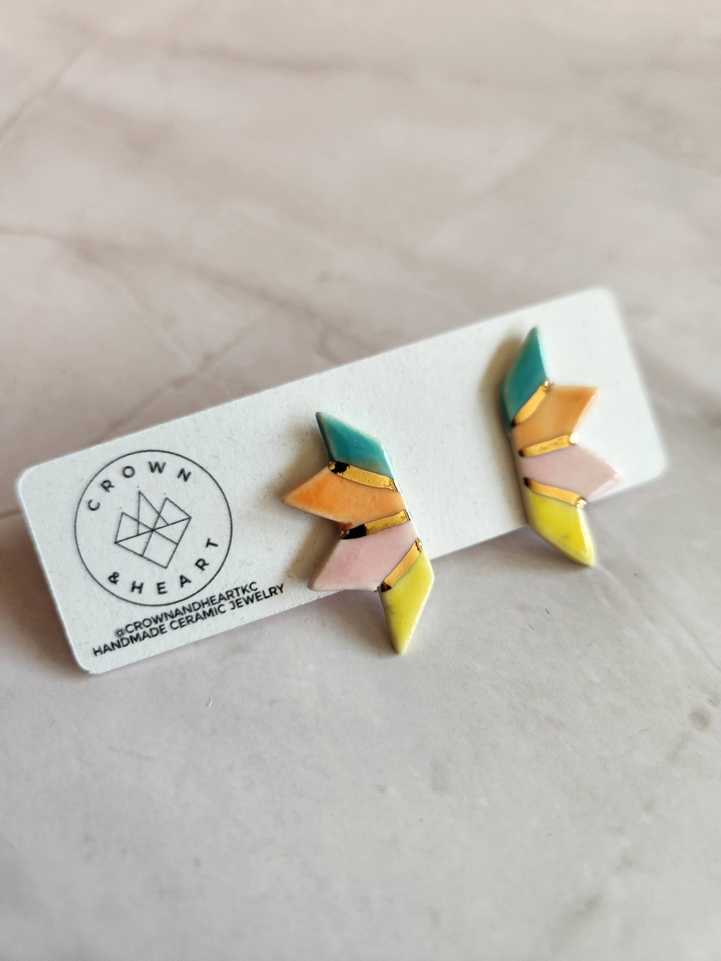 Colorful geometric earrings on a white card with 'Crown & Heart' branding.