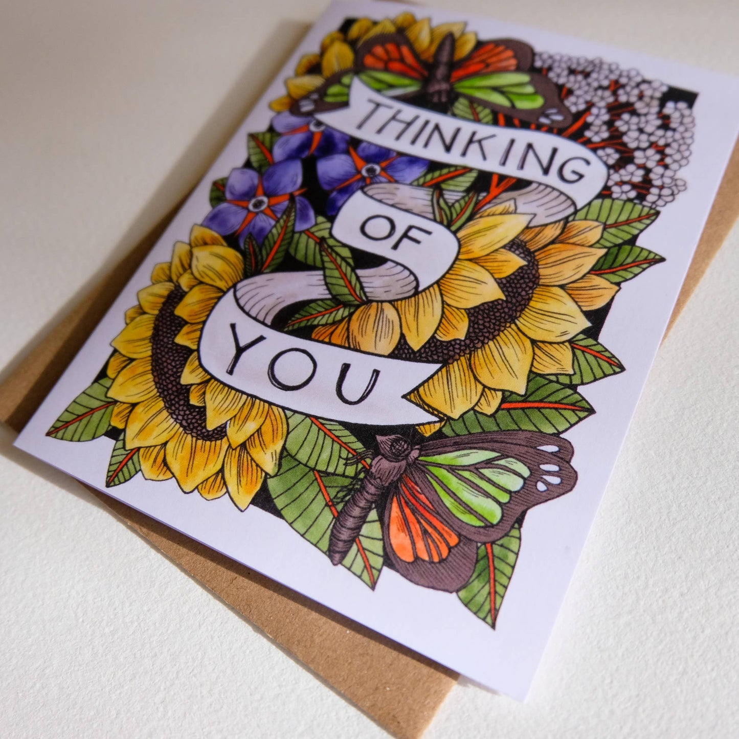 Greeting card with floral design and 'Thinking of You' text on a white background