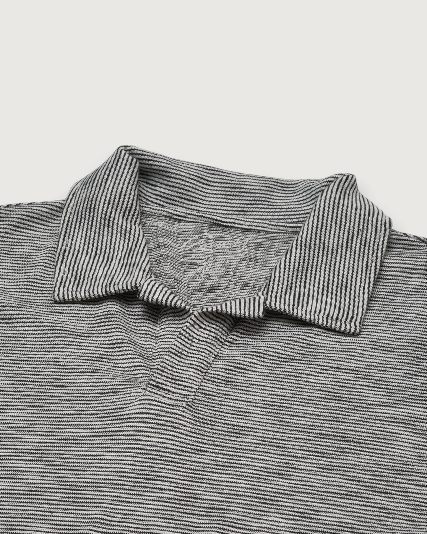 Close-up of a gray and white striped polo shirt on a light gray background