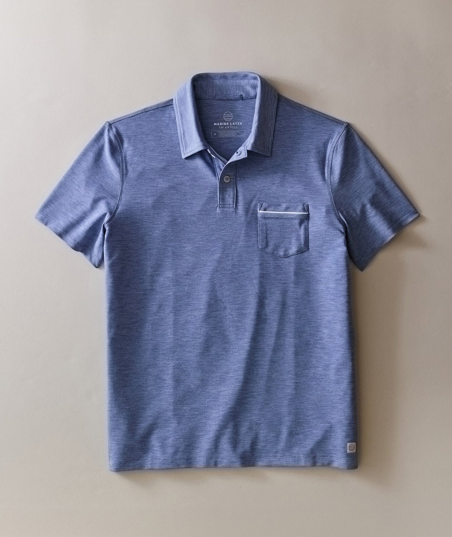 Blue polo shirt with a pocket on a beige background
