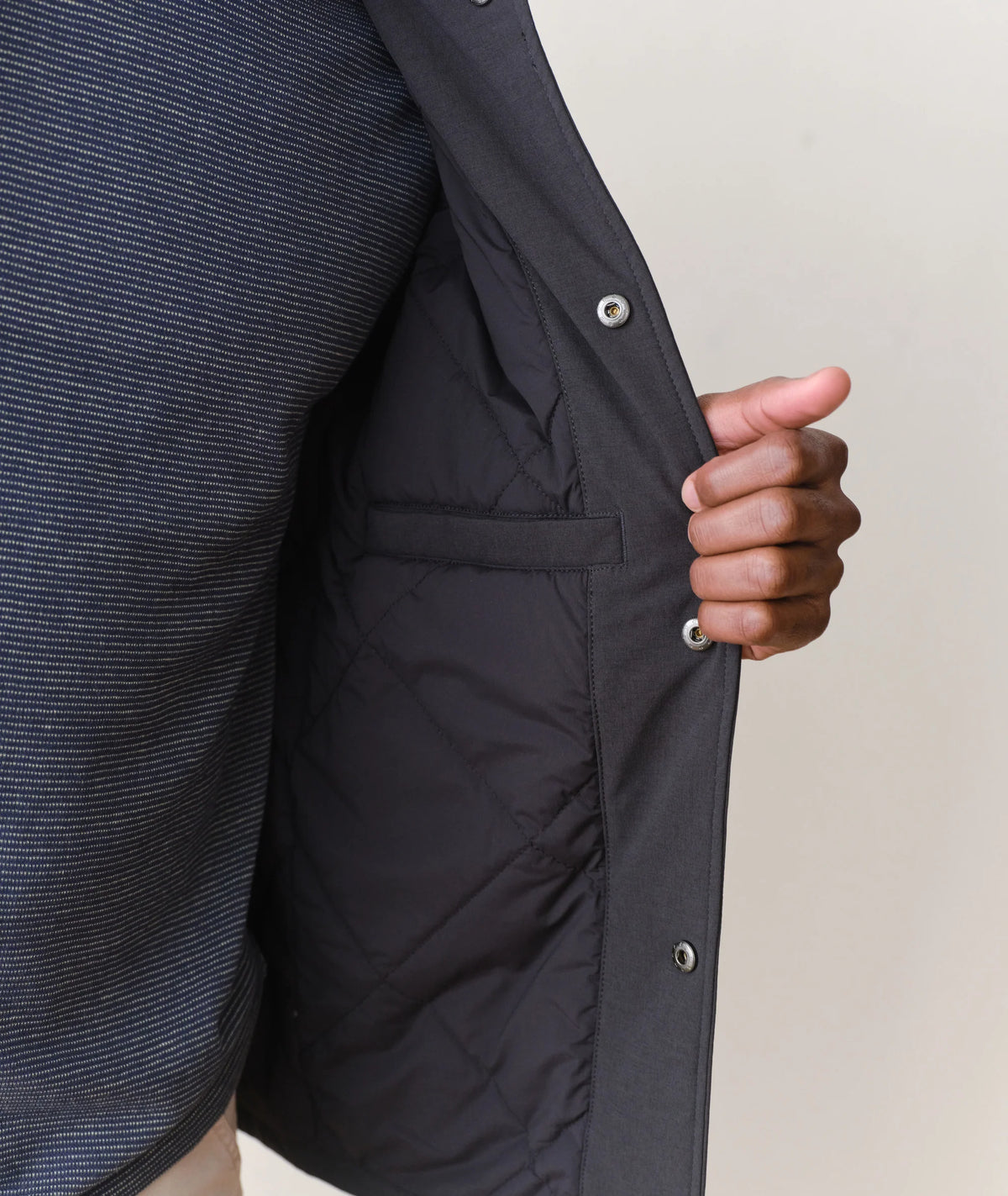 Person wearing a black jacket with a neutral background