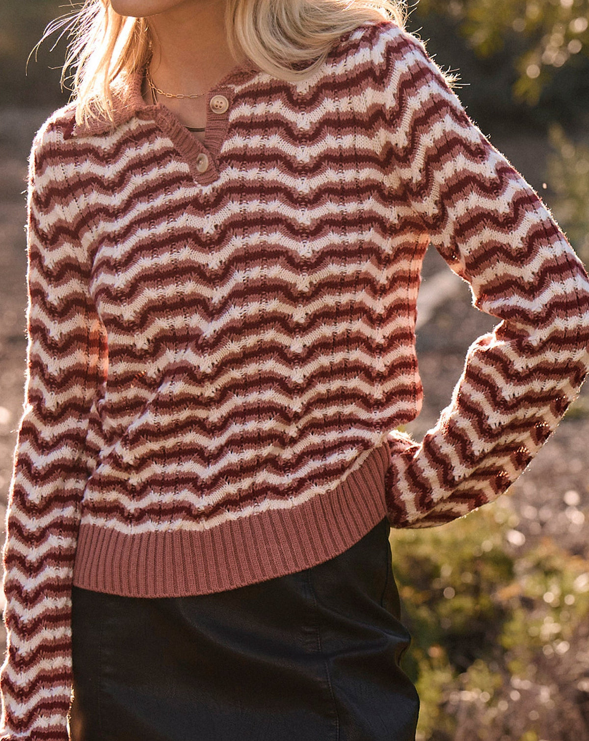 Woman wearing a striped sweater and black skirt outdoors