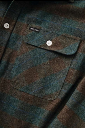 Plaid shirt with a visible brand label on a close-up of a pocket.
