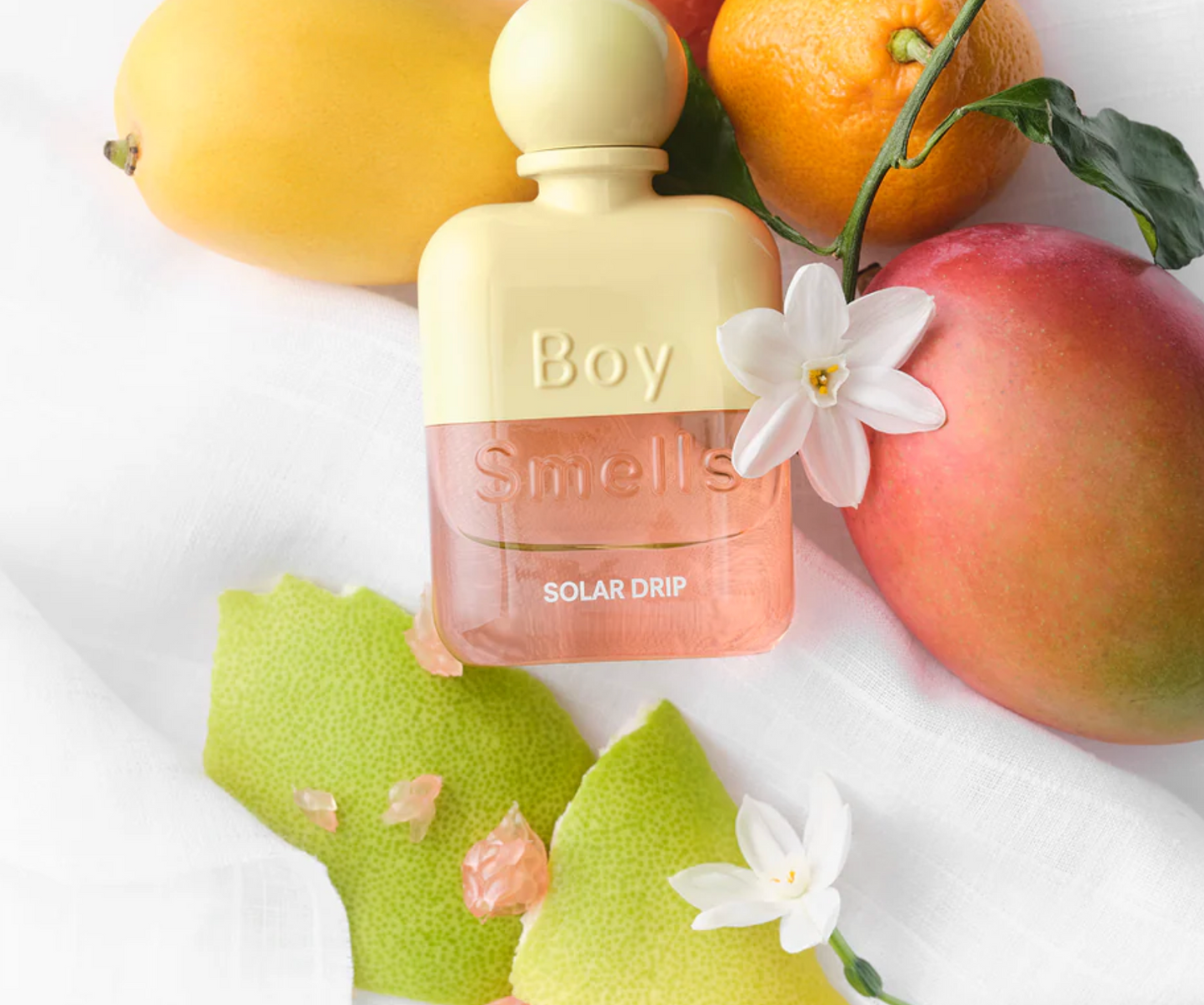 Perfume bottle labeled 'Boy Smells' with fruits and flowers on a white background