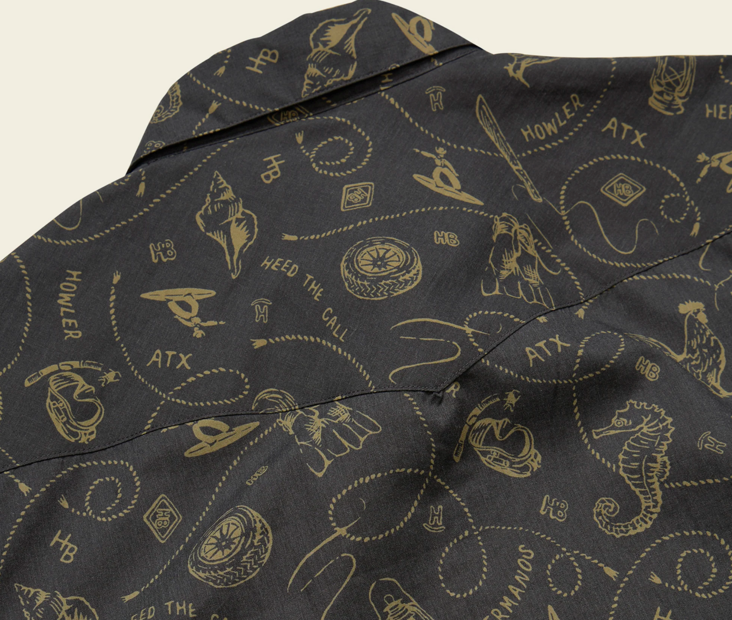 Dark fabric with gold patterns and text, including 'Howler' and 'ATX'.
