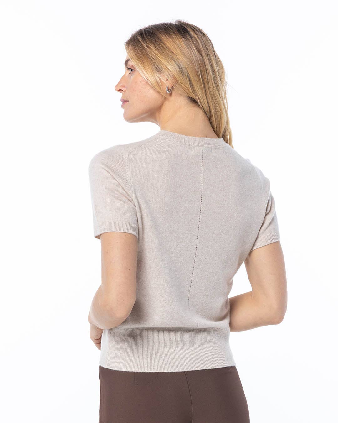 Woman wearing a light gray short-sleeve top on a white background