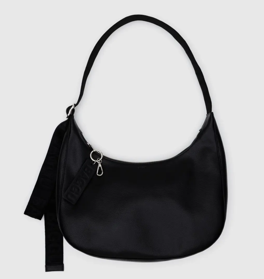 Black handbag with a strap on a light gray background
