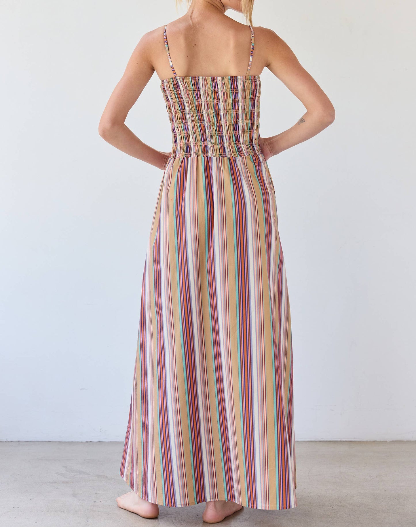 Woman wearing a colorful striped dress against a white background