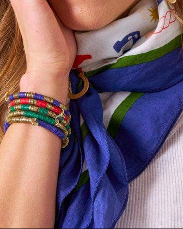 Woman wearing a colorful scarf, earrings, and bracelets on a white background