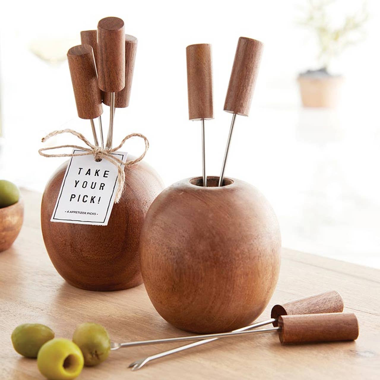 Wooden apple-shaped fruit skewer sets with a 'Take Your Pick!' tag on a wooden surface.