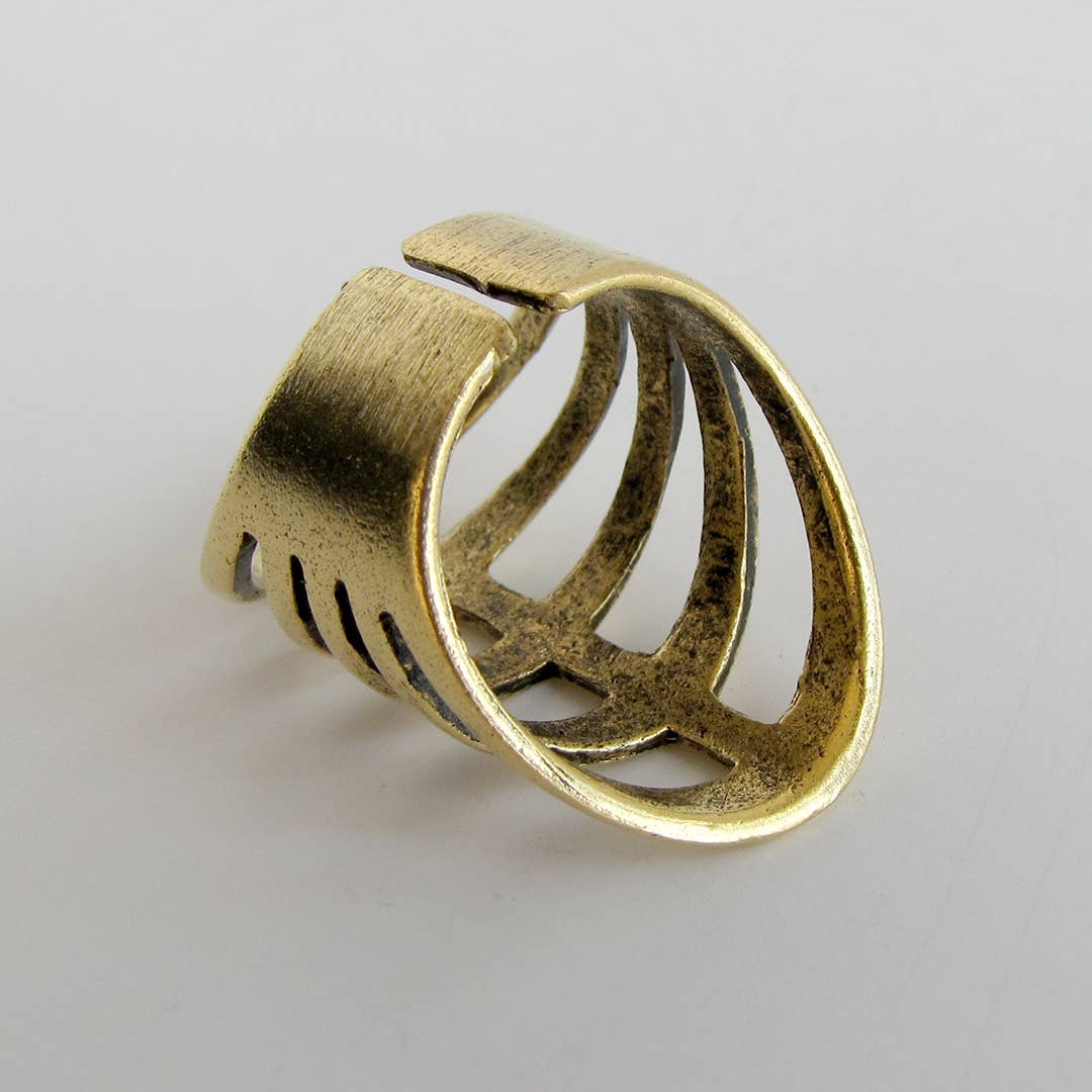 Gold metal ring with a unique design on a light gray background