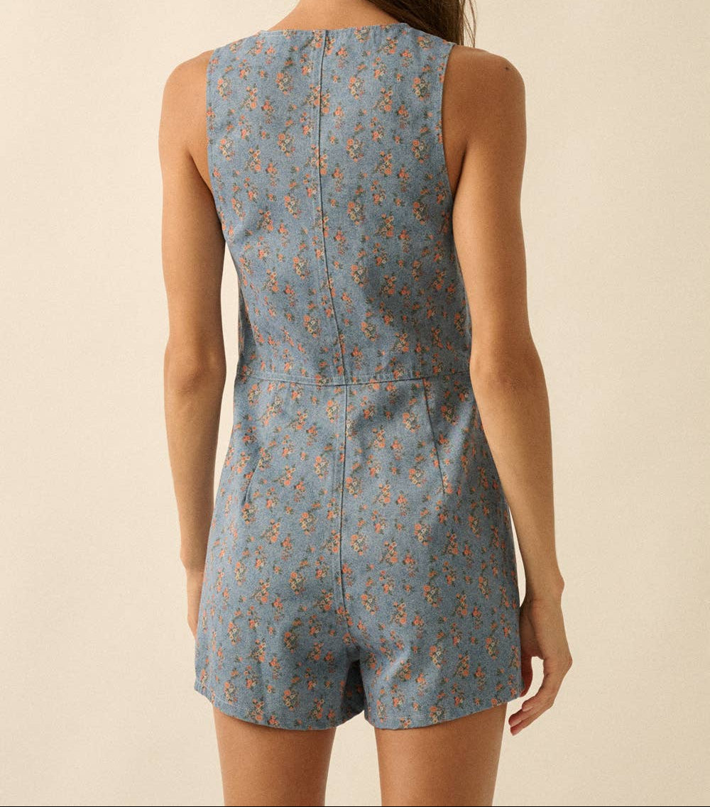 Woman wearing a blue floral romper against a beige background