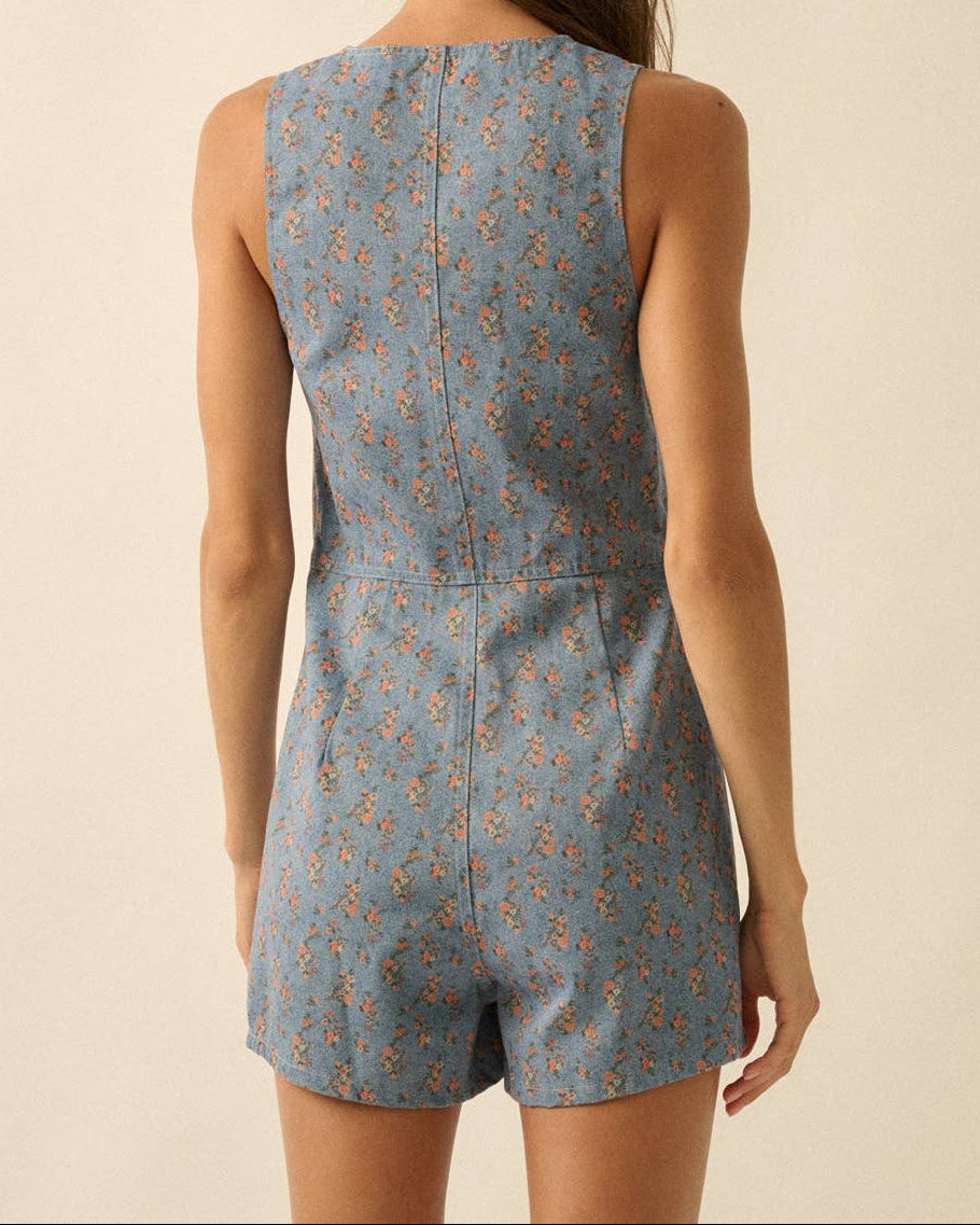 Woman wearing a blue floral romper against a beige background