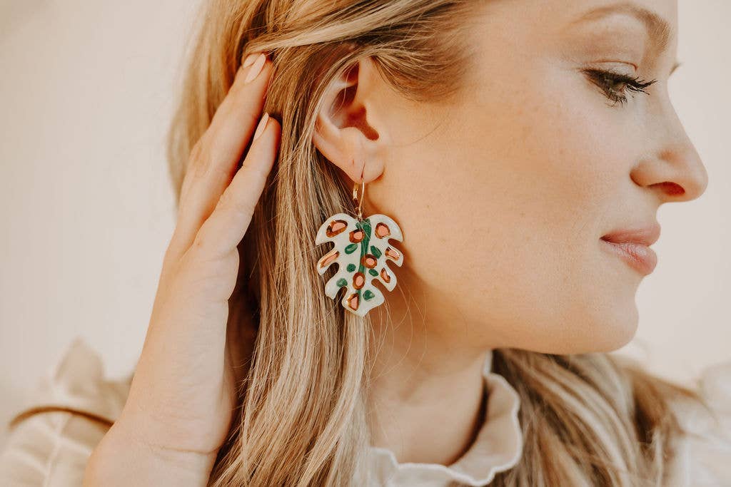 Close-up of a woman wearing a floral earring with a blurred background