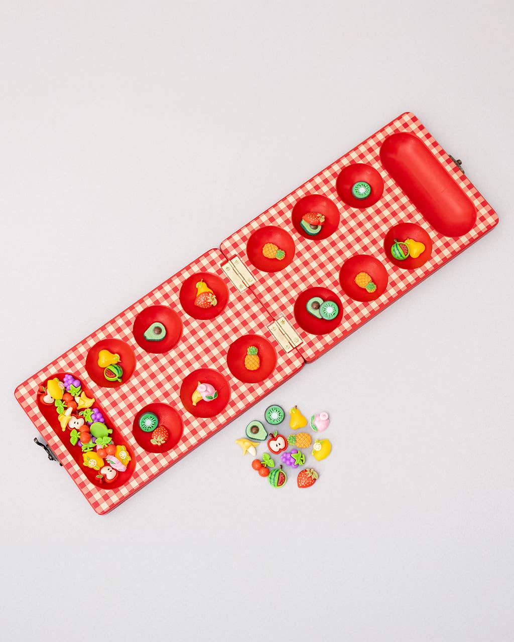 Red checkered mat with colorful fruit and vegetable designs on a light gray background