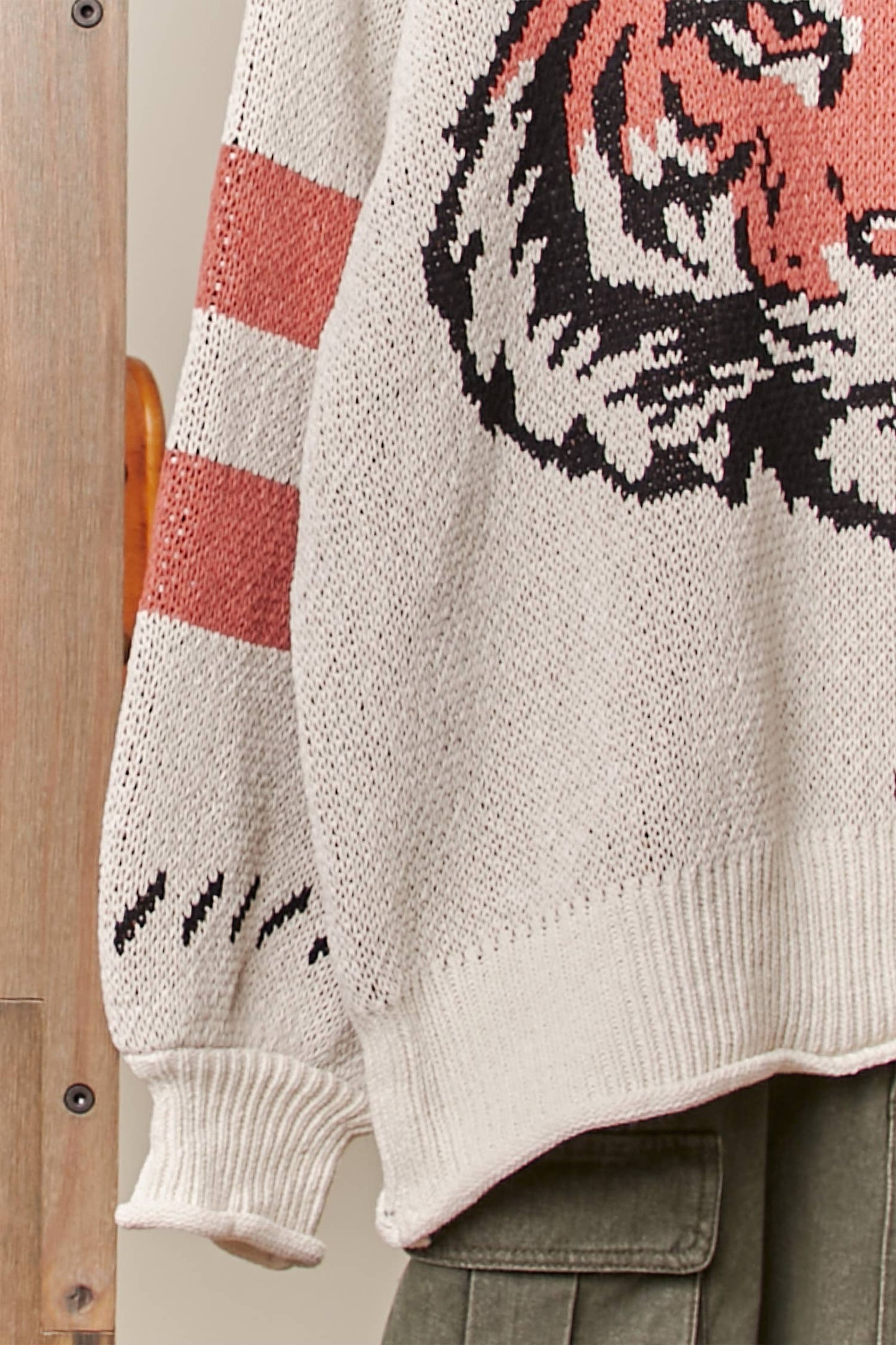 Knitted sweater with a tiger design on a wooden surface