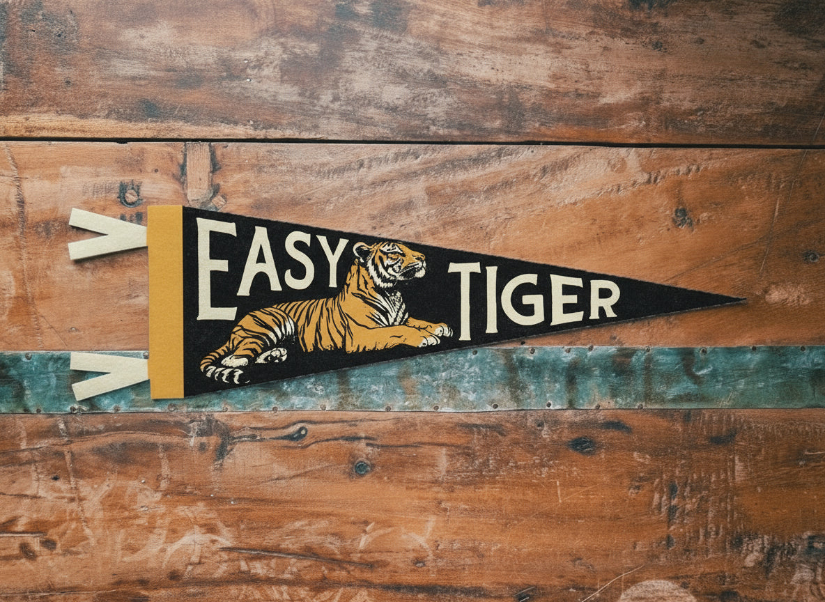 Decorative pennant with tiger design and 'Easy Tiger' text on a wooden surface.
