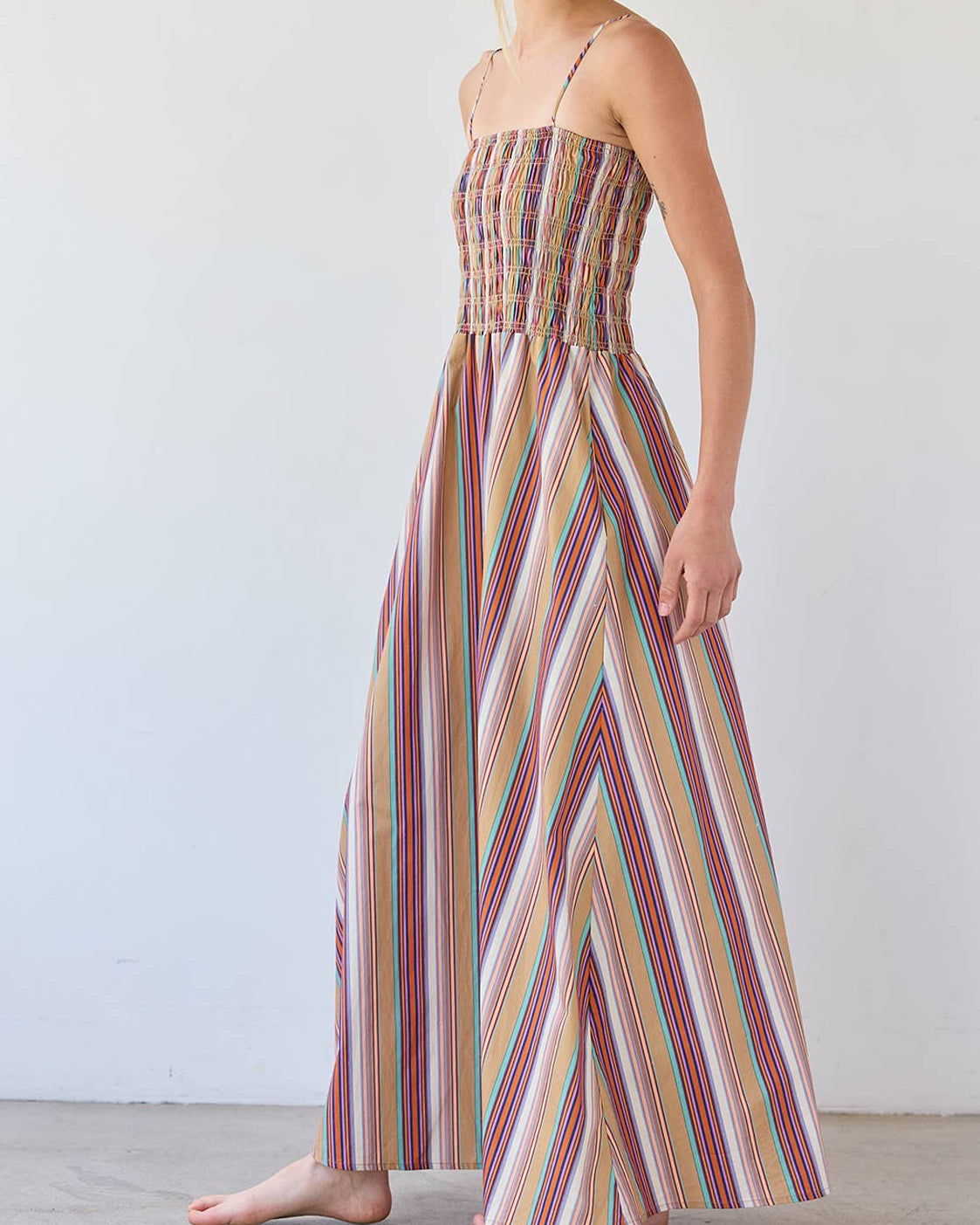 Woman wearing a colorful striped dress against a white background
