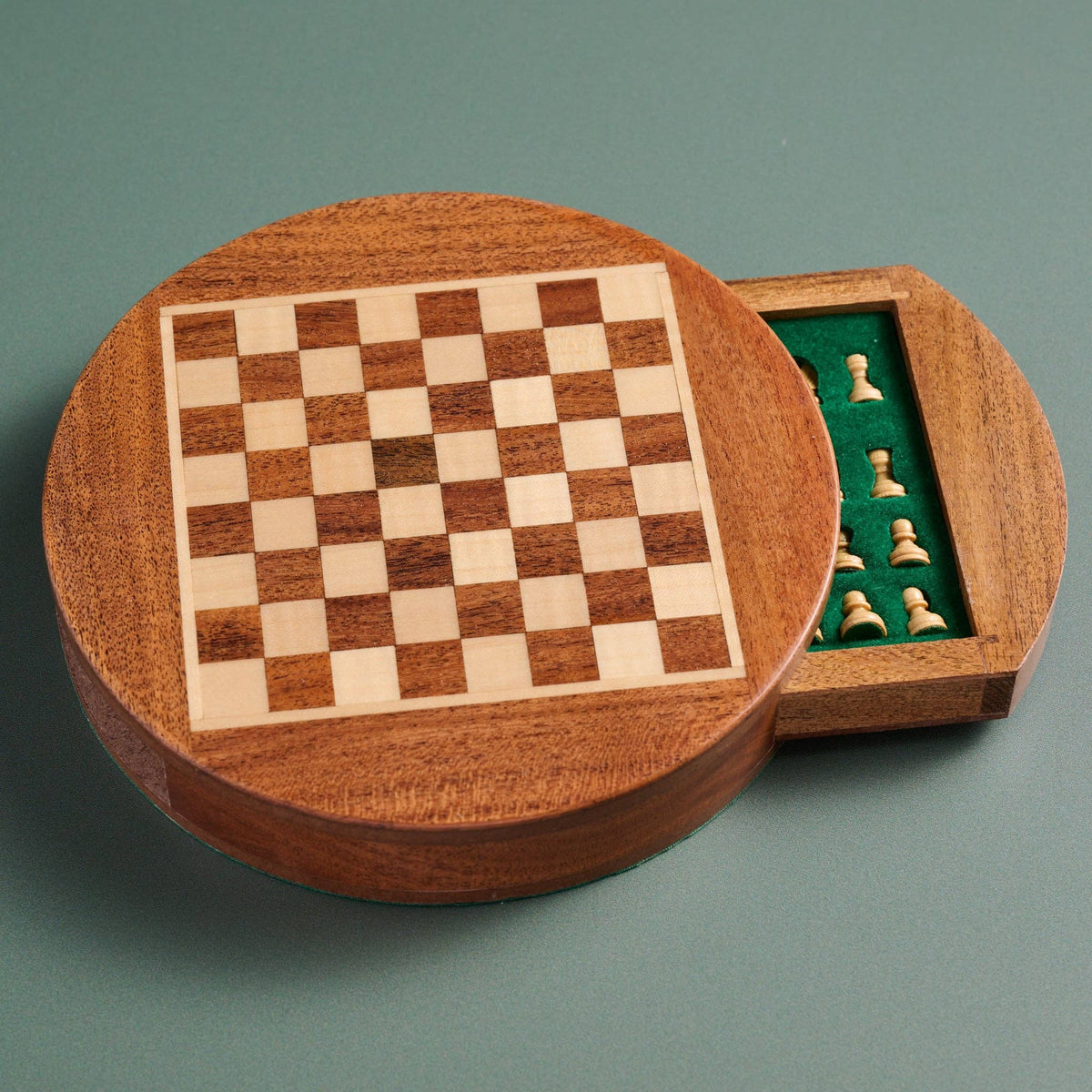 Wooden chess set with checkered board and pieces on a green background