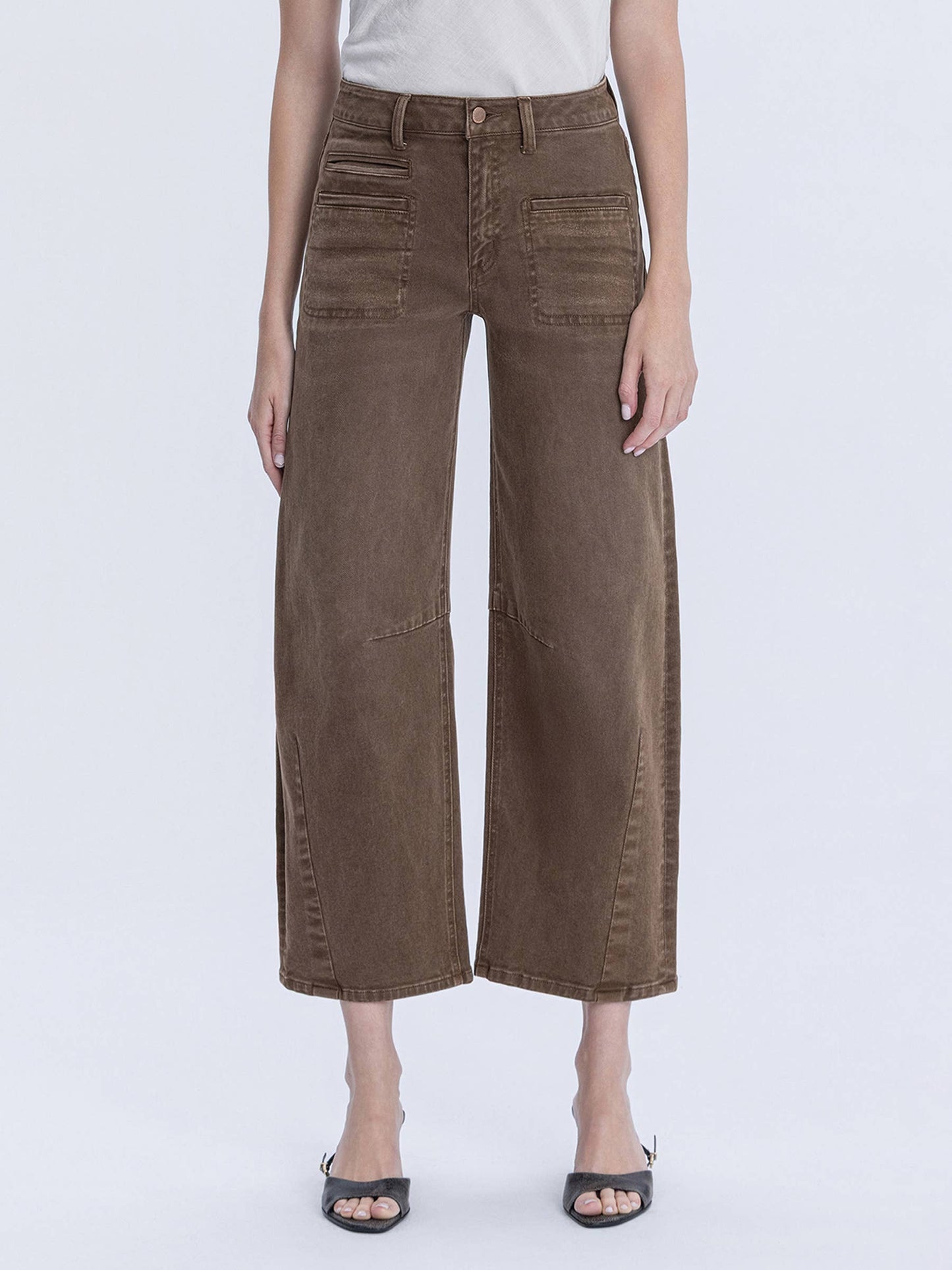 Person wearing brown wide-leg pants on a white background