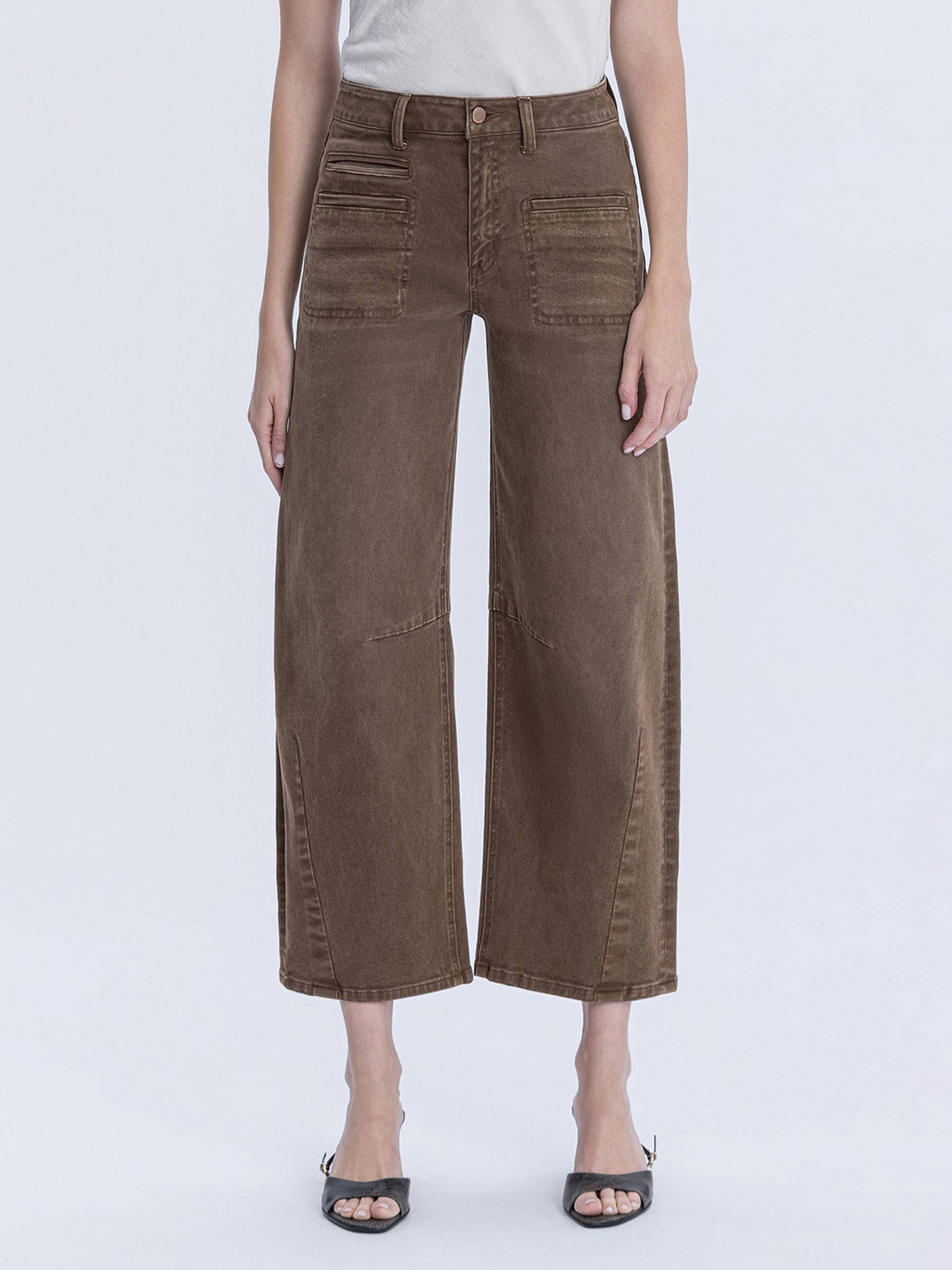 Person wearing brown wide-leg pants on a white background