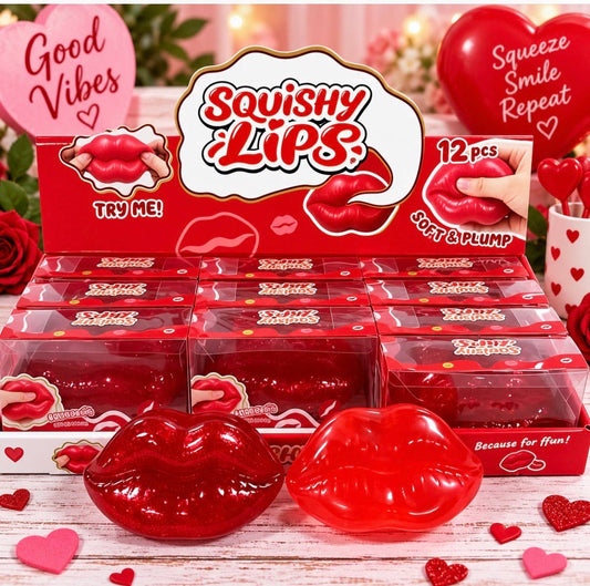 A retail display box of red 'Squishy Lips' novelty gummy candies, with two large red lip-shaped gummies in the foreground and multiple small clear boxes of the same product arranged behind them on a white rustic surface.