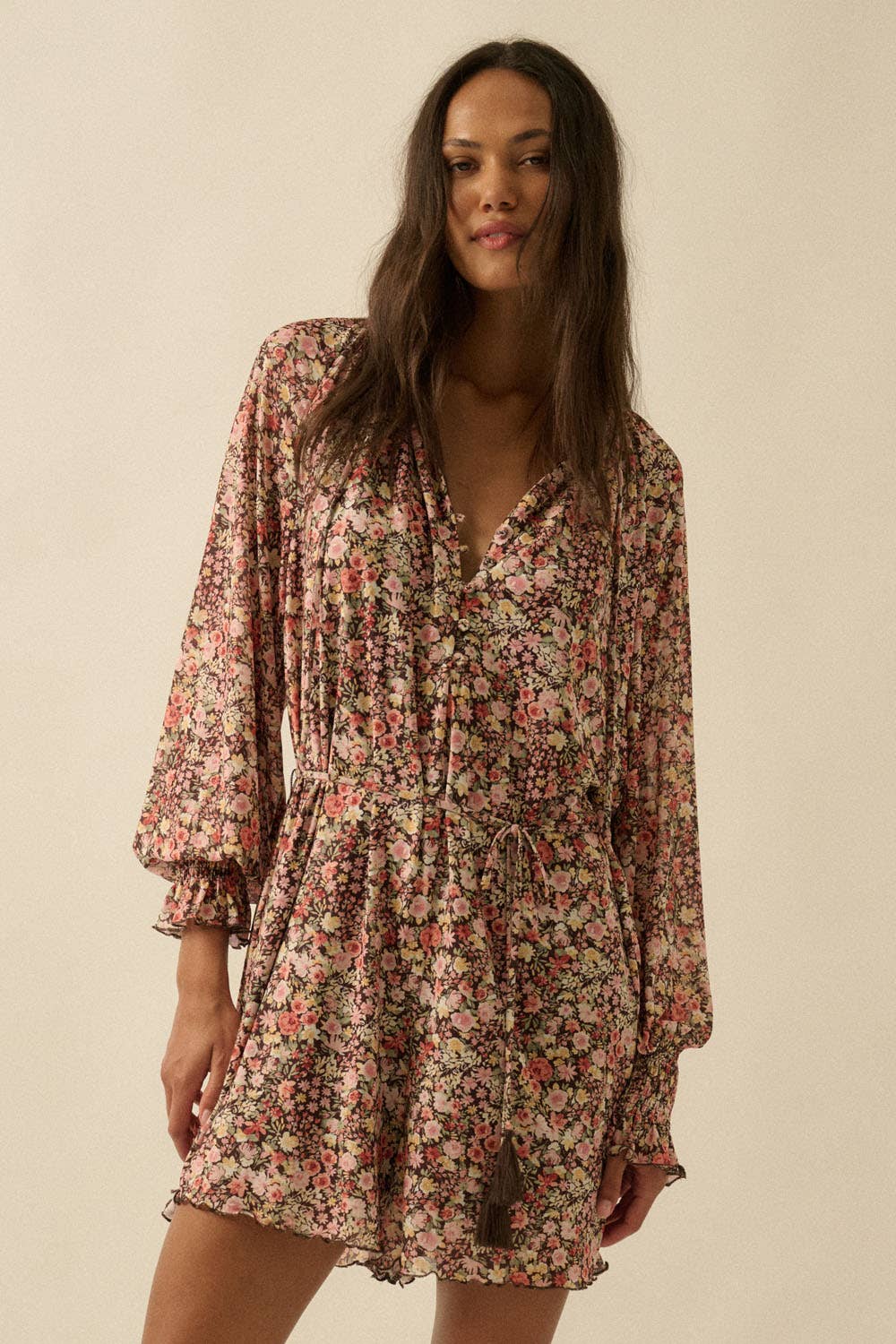 Woman wearing a floral dress against a plain background