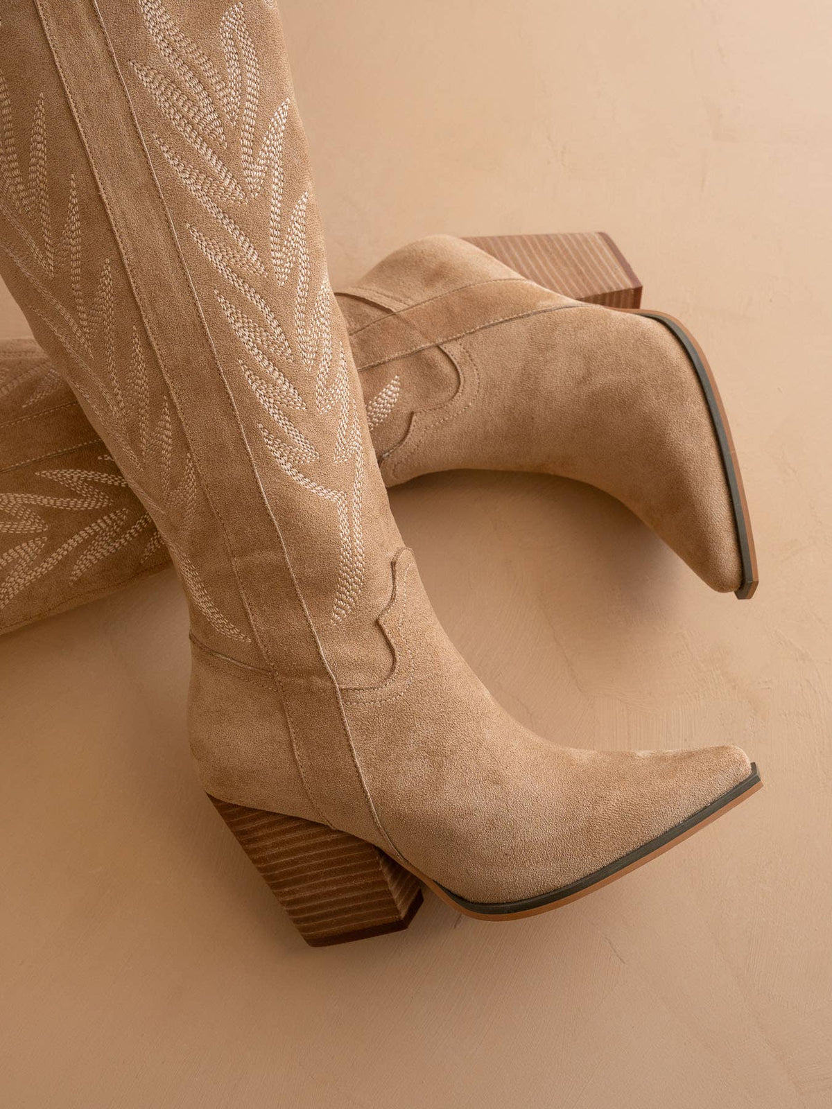 Beige cowboy boots on a beige background