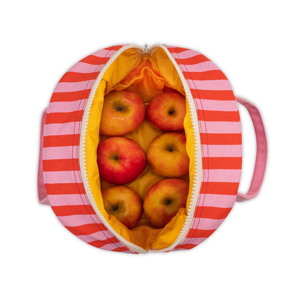 Red and white striped bag filled with apples on a white background