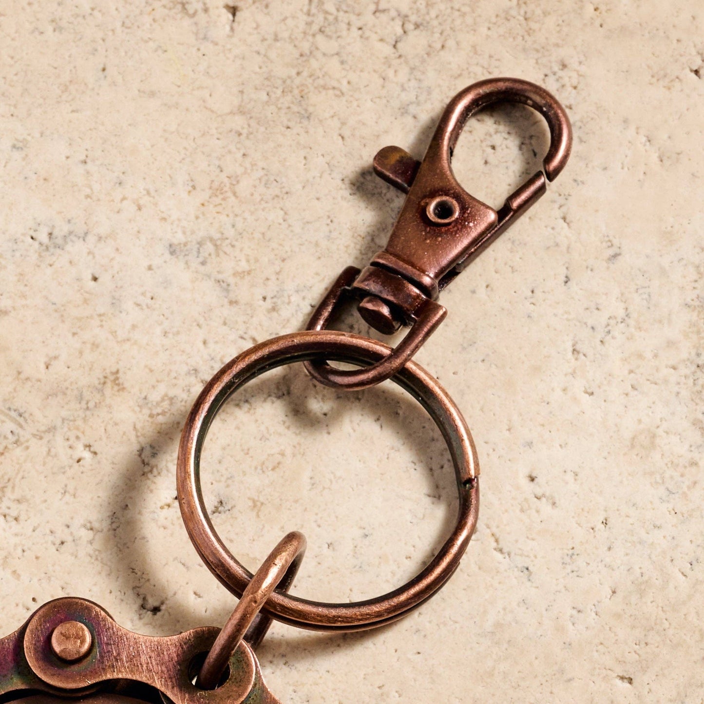 Copper keychain with a clasp on a beige background