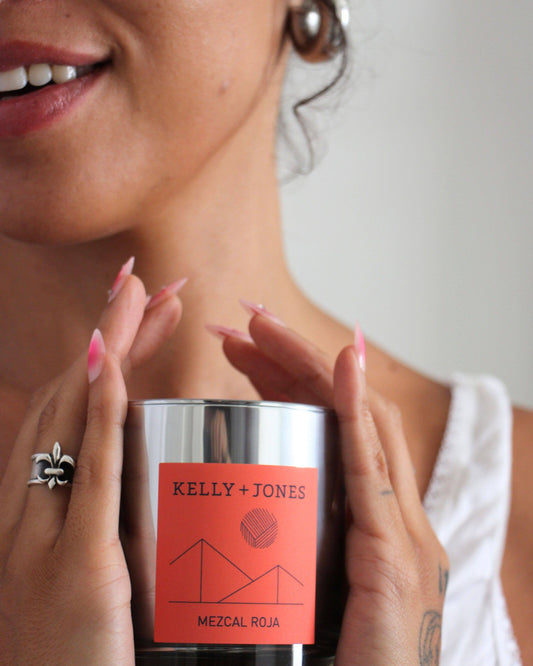 Person holding a Kelly + Jones candle with a neutral background