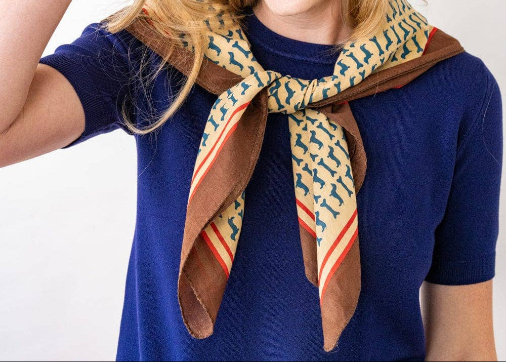 Woman wearing a patterned scarf and bracelets on a white background