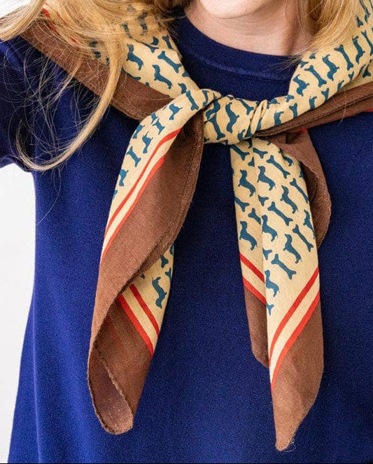 Woman wearing a patterned scarf and bracelets on a white background