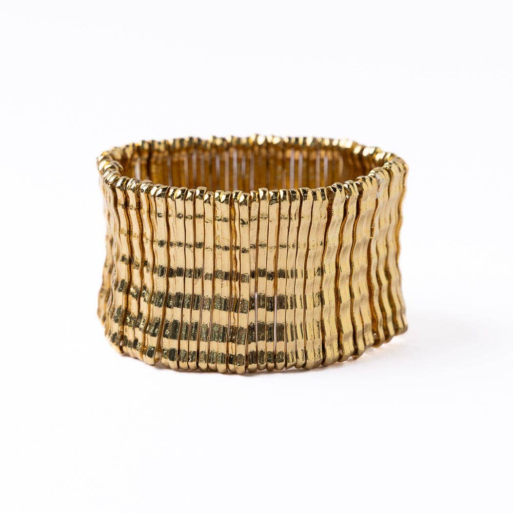Gold bracelet with textured pattern on a white background