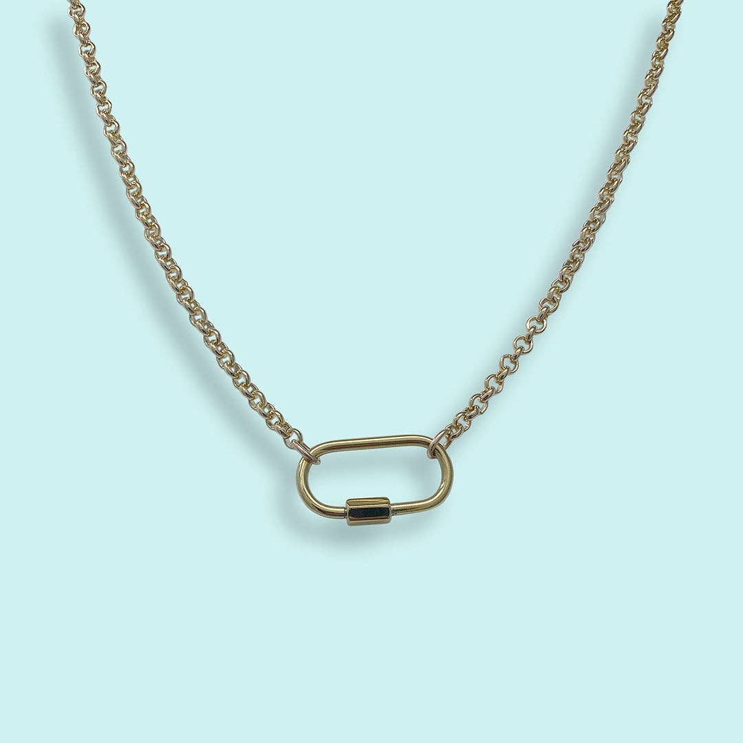 Gold necklace with a unique clasp on a light blue background
