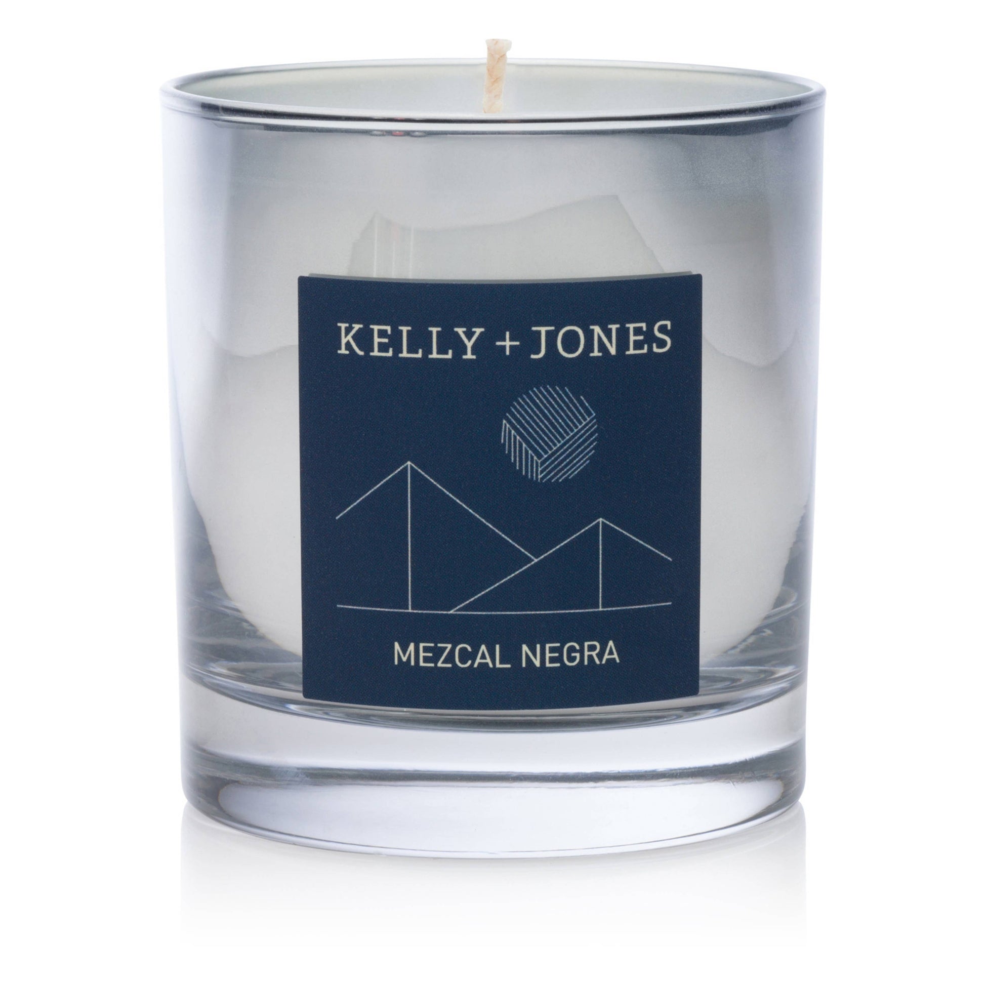 Clear glass candle with a navy label featuring 'Kelly + Jones' and 'Mezcal Negra' on a white background.