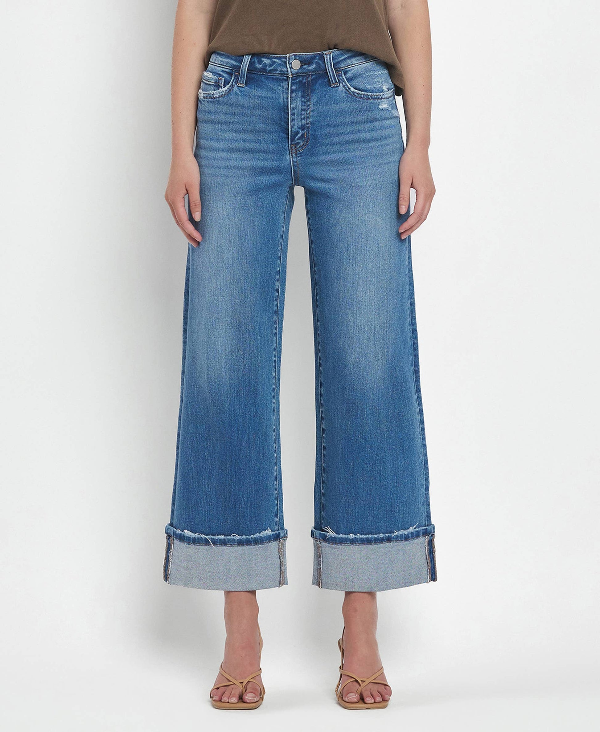 Person wearing blue wide-leg jeans on a white background