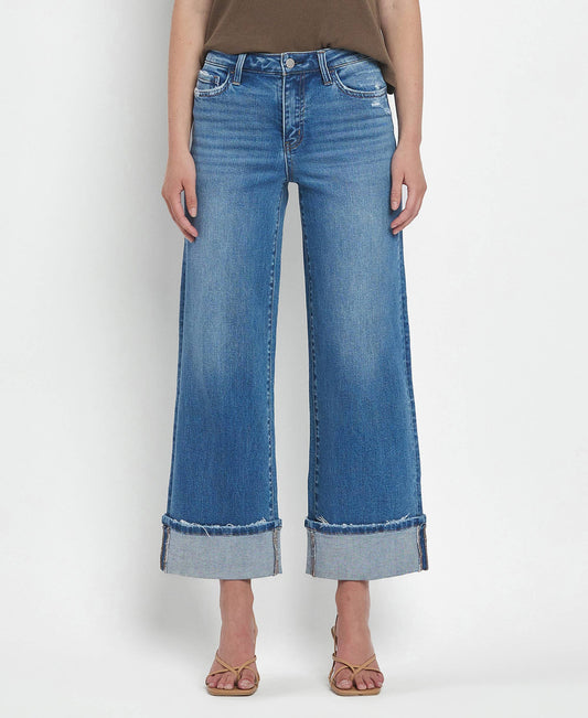 Person wearing blue wide-leg jeans on a white background