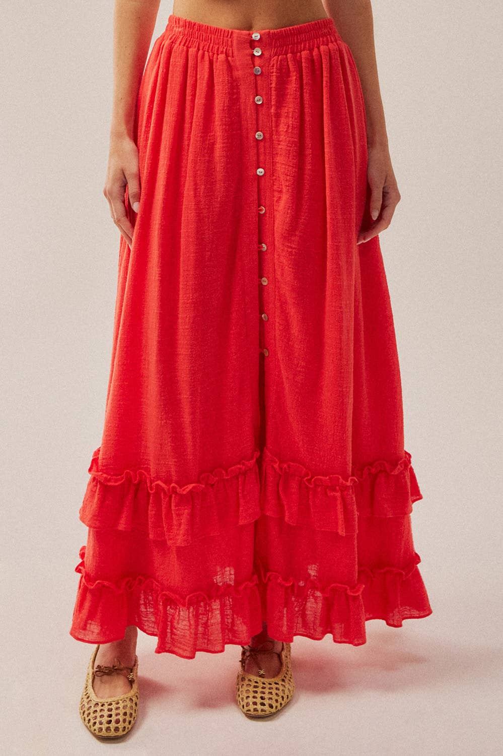 Red ruffled skirt worn by a person on a plain background