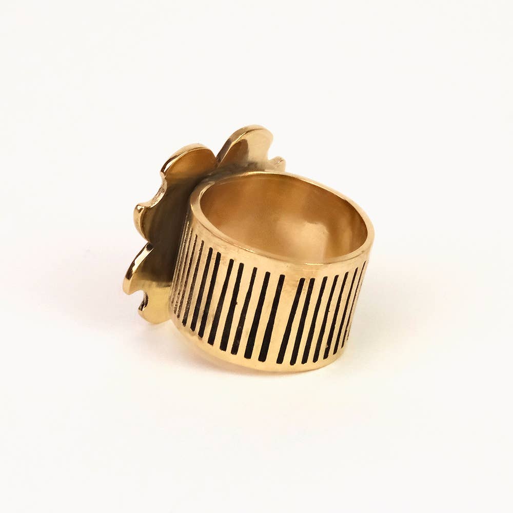 Gold ring with a black striped design on a white background